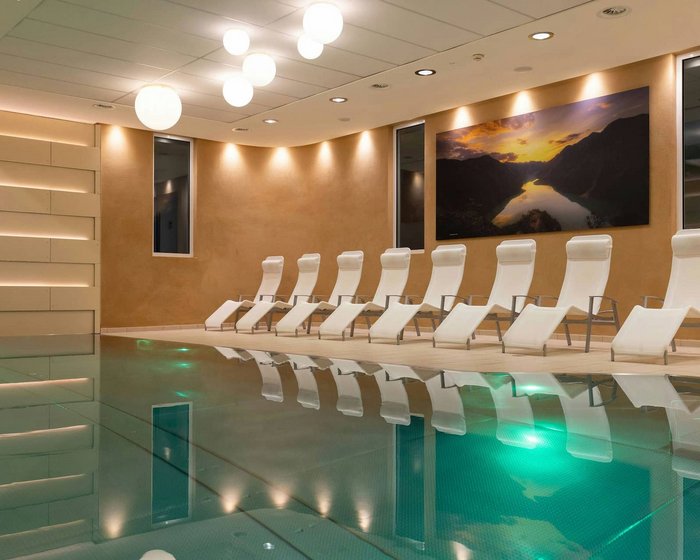 Beheiztes Hallenbad im Hotel zum Mohren mit Ruheliegen und stimmungsvoller Beleuchtung.